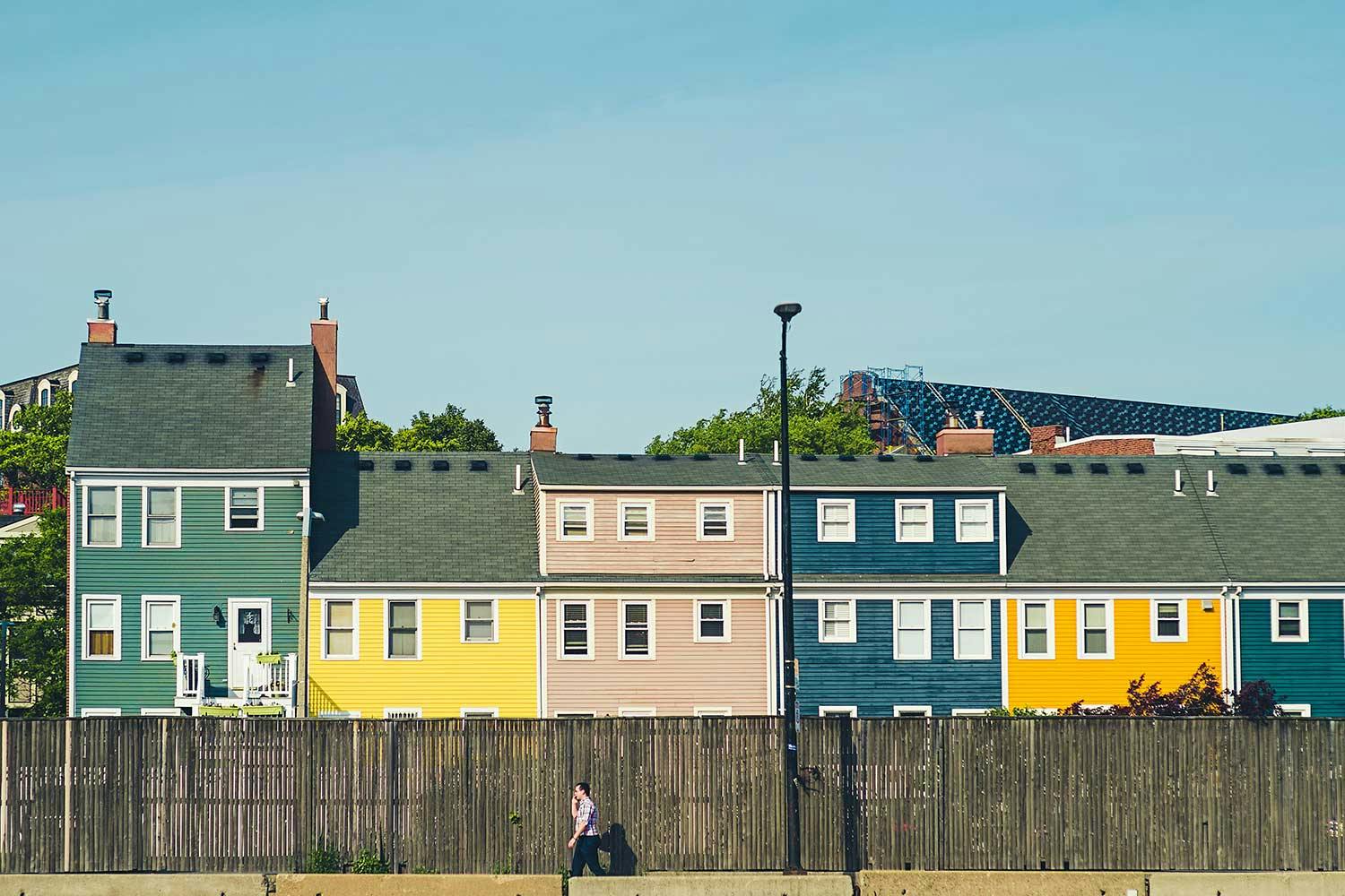 A row of colourfully painted houses with white framed windows.