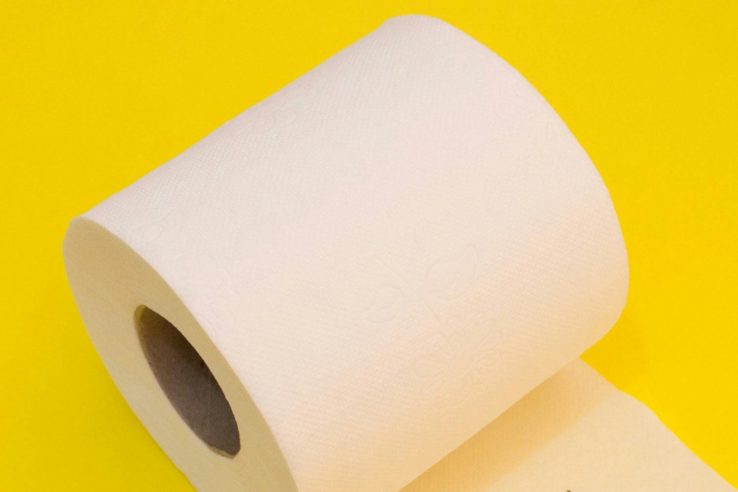 A roll of toilet paper on a yellow background.