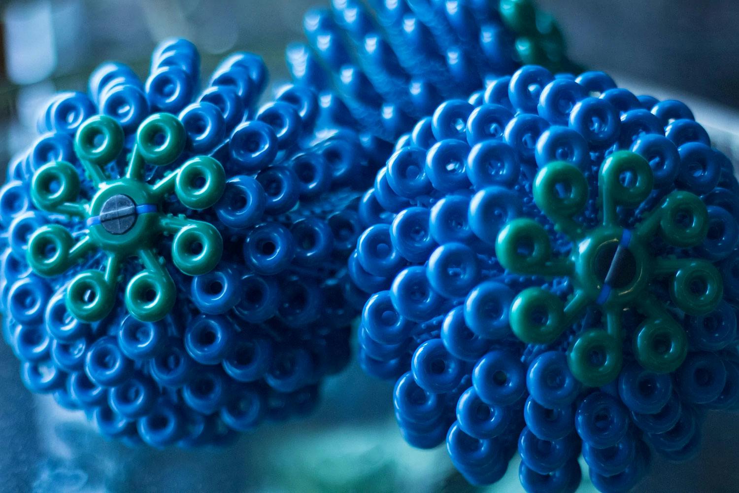 Three cora balls—blue plastic balls with ring-shaped protrusions that mimic coral that capture microplastics in the laundry.
