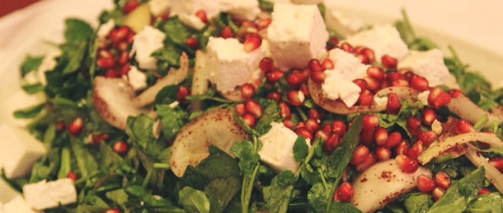 Jarjeer salad—made with watercress topped with onion, cubes of cheese, and pomegranate.